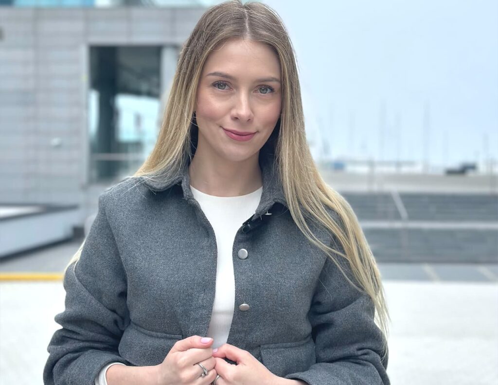 Paulina Stępniewska w szarym płaszczu na zewnątrz. Paulina jest niezależną ekspertką kredytową gotową do pomocy swoim klientom.