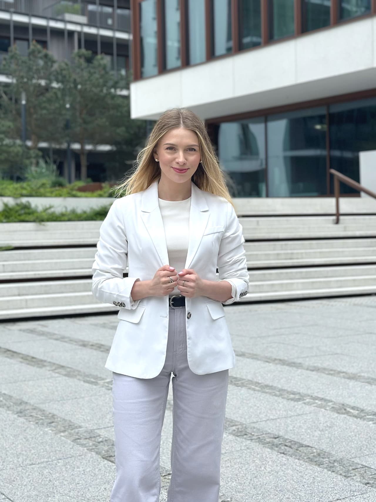 Paulina Stępniewska, niezależna ekspertka kredytowa, kobieta w białej marynarce przed budynkiem, symbol profesjonalizmu i zaufania.